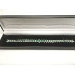 A boxed 18ct white gold graduated emerald and diam