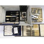 A wooden box containing various cutlery both cased