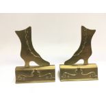 A pair of brass place holders in the form of boots