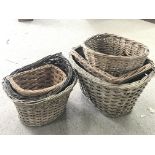 Six vintage wicker bike baskets of various sizes.