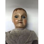 A Victorian wooden and leather doll with pained ha