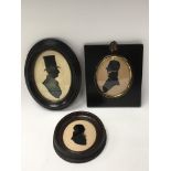 Three framed silhouette portrait miniatures.