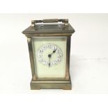 A brass cased carriage clock with a coloured dial