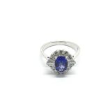 An 18ct white gold tanzanite and diamond cluster ring, oval-cut tanzanite 1.16ct. RBC and tapered ba