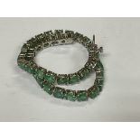 A sterling silver and emerald set line bracelet.