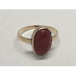 An unmarked gold ring set with an oval cabochon. R