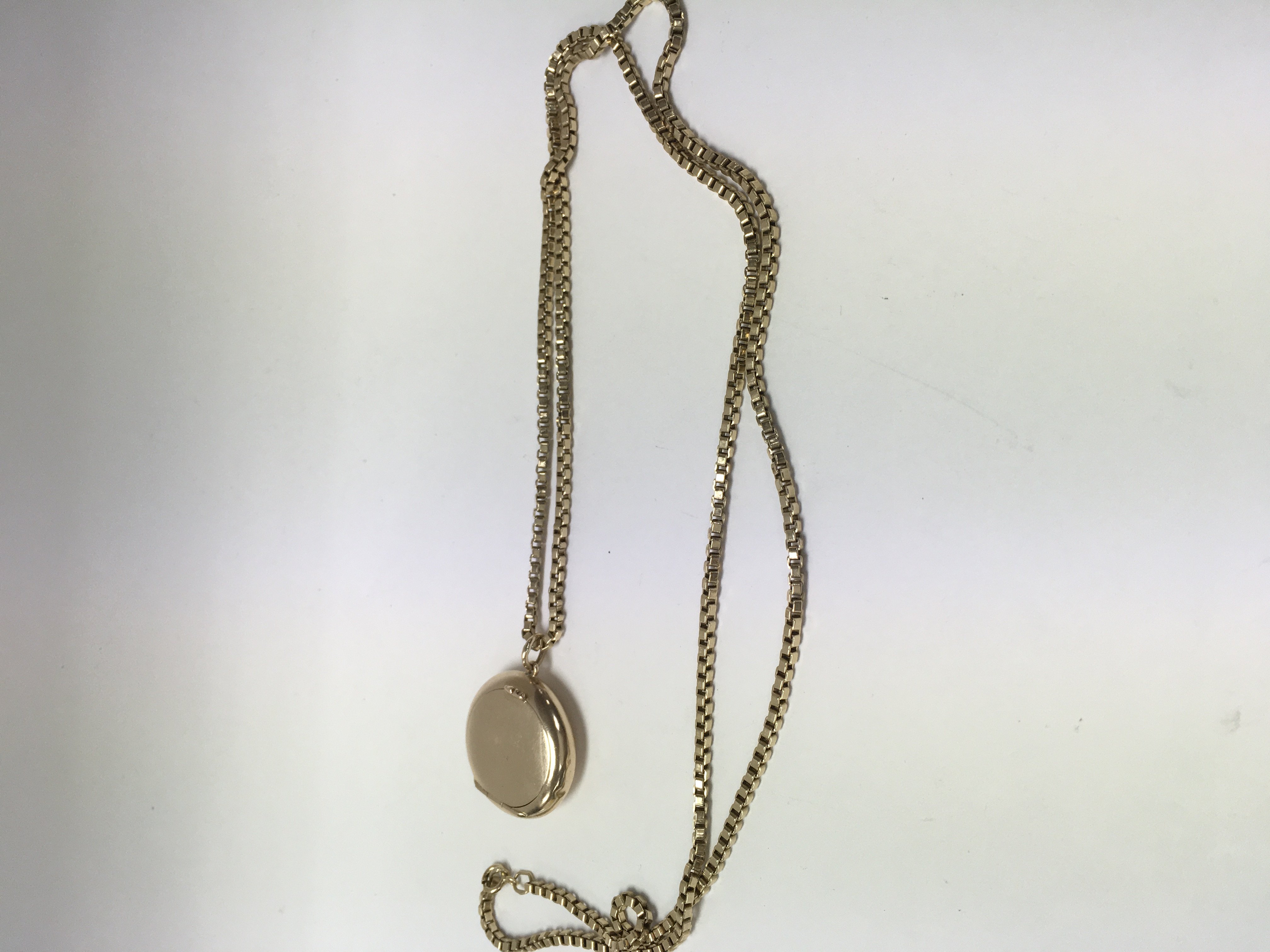 A 9 ct gold chain with attached 9 ct pill box tota