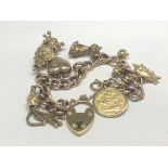 A 9ct gold charm bracelet with attached Victorian