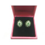 A pair of 9ct gold earrings set with emeralds and
