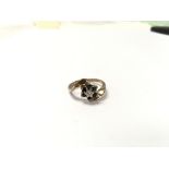 A gold ring set with sapphires and a small diamond in the shape of a flower. The approximate ring