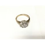 A stone set daisy cluster ring set in gold. Size R