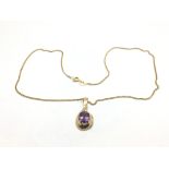 A 9ct gold amethyst pendant suspended on a gold ch