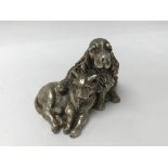 A silver casting in the form of a dog and cat .