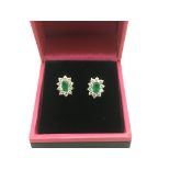 A pair of 9ct white gold earrings set with green a