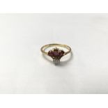 An 18ct gold ring set with three rubies and a diamond. The approximate ring size is between K and