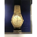 A boxed Seiko wrist watch with gold plated strap.