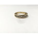 An 18ct gold ring set with a row of diamonds, measuring approximately ring size K.