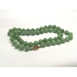 A Vintage jade bead necklace with a filigree clasp