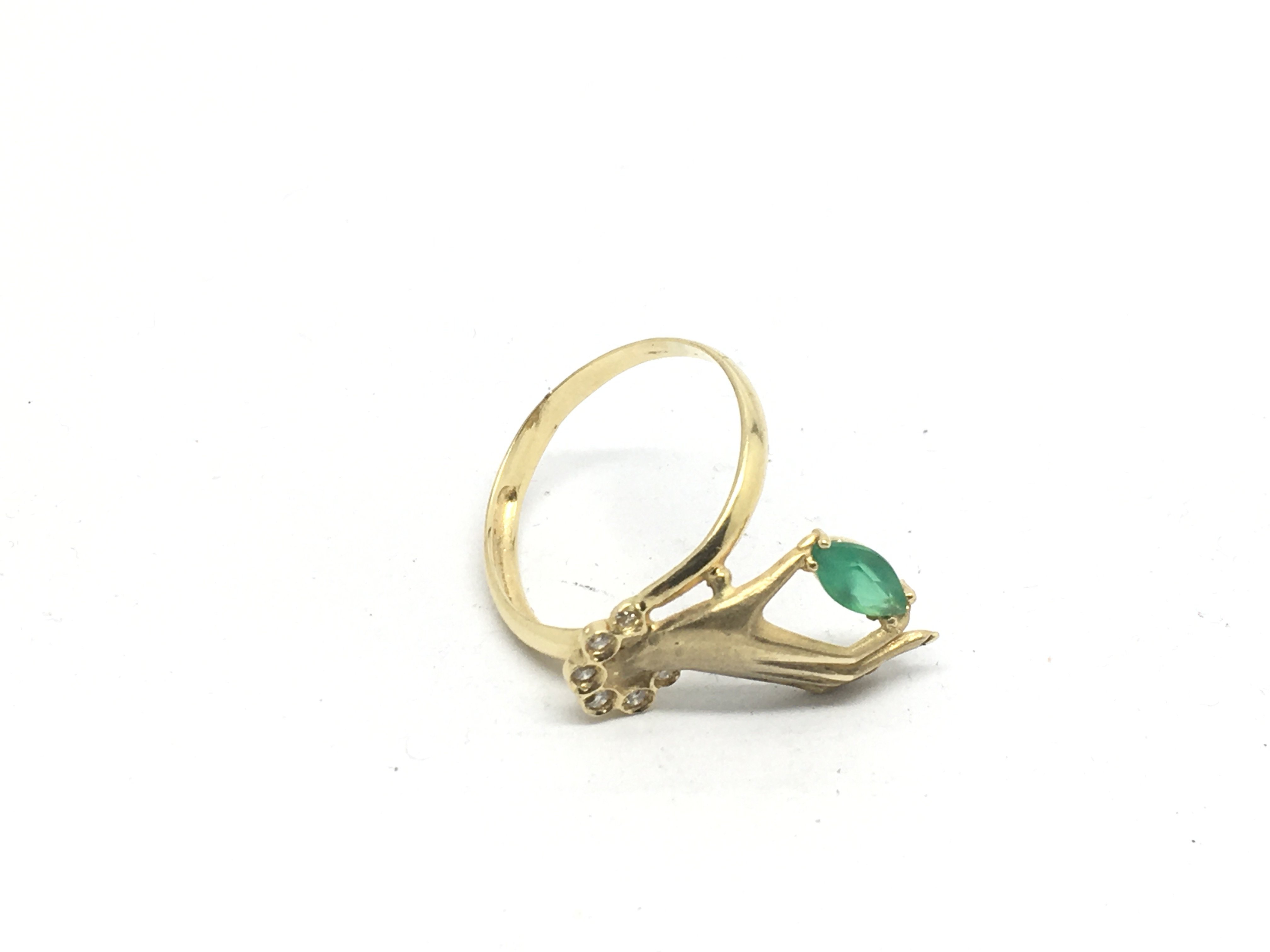 A gold, emerald and diamond ring in the form of a