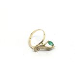 A gold, emerald and diamond ring in the form of a