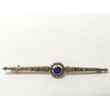 A gold french brooch set with a cornflower sapphire.