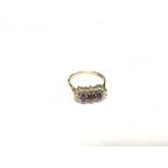 An amethyst triple cluster ring in 9ct gold. Size