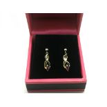 A pair of 9ct gold drop earrings set with a ruby,