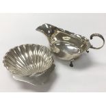 A silver sauce boat and a silver shell shaped dish, weighing approximately 152g.