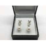 A pair of 9ct white gold drop earrings with diamon