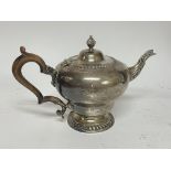 A silver tea pot with stylised spout and wood handle, London Hallmarks, approximately 846g