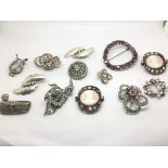 A collection of silver and paste brooches and pend