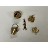 A collection of gold charms to include a grenadier