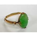 An unmarked gold ring set with a jade stone.