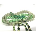 A collection of four long vintage green jade and o