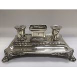 A Victorian silver double inkstand, the inkwells decorated with swags and the whole raised on animal