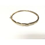 A gold bangle with 25 diamonds.