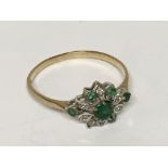 A emerald and diamond ring set in gold. Ring size