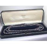 A long strand of coloured cultured pearls in a fit