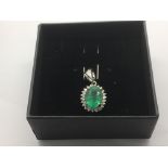 An 18ct white gold oval cut emerald and round cut