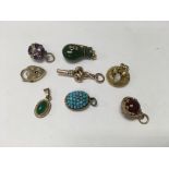 A Collection of eight charm pendants including gol