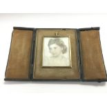 A 1950s watercolour miniature of a lady in a gold plated frame and presented in a folding leather