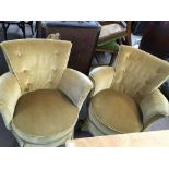 A pair of mustard coloured upholstered tub chairs.