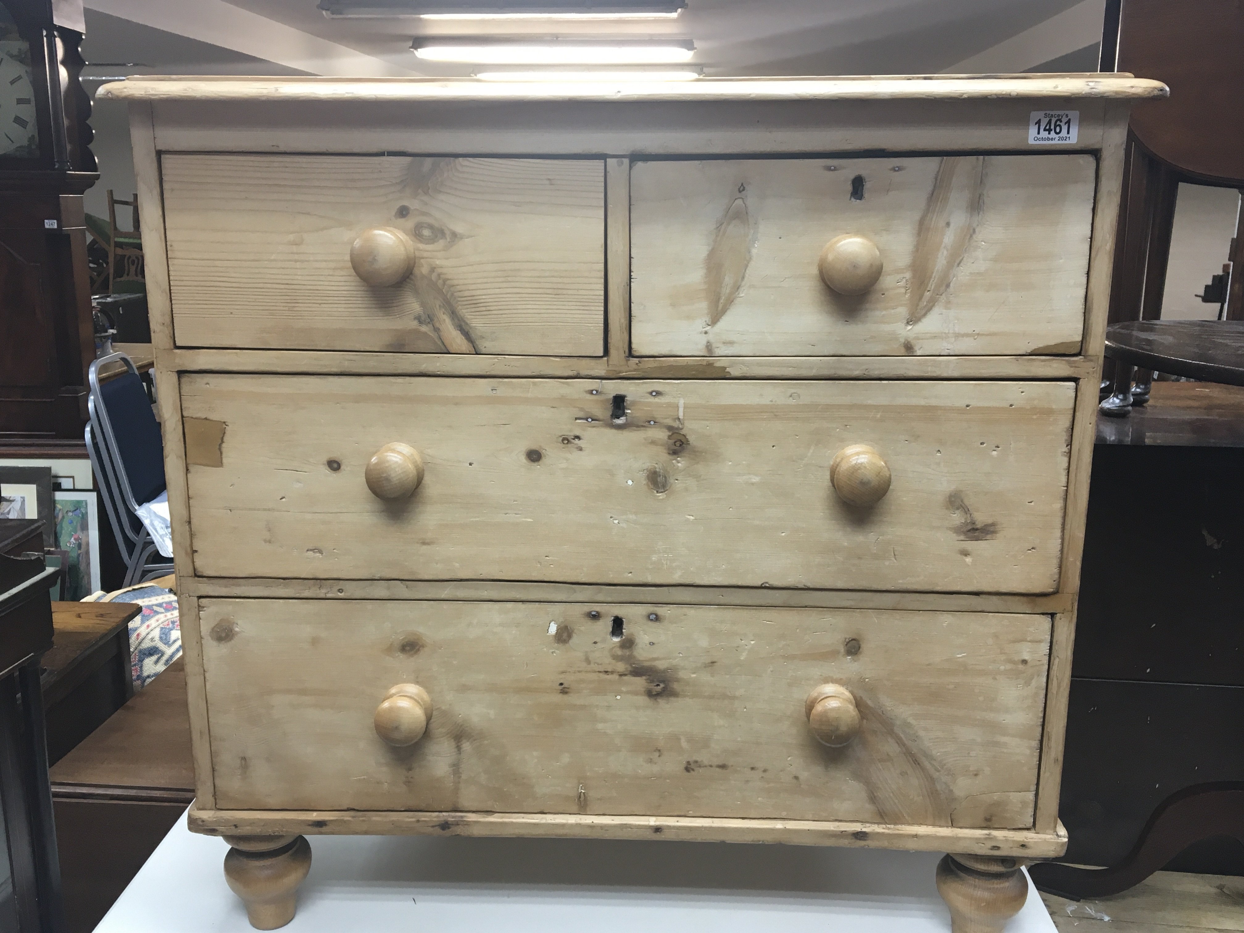 A small pine chest of drawers fitted with two short and two long drawers on turned feet.