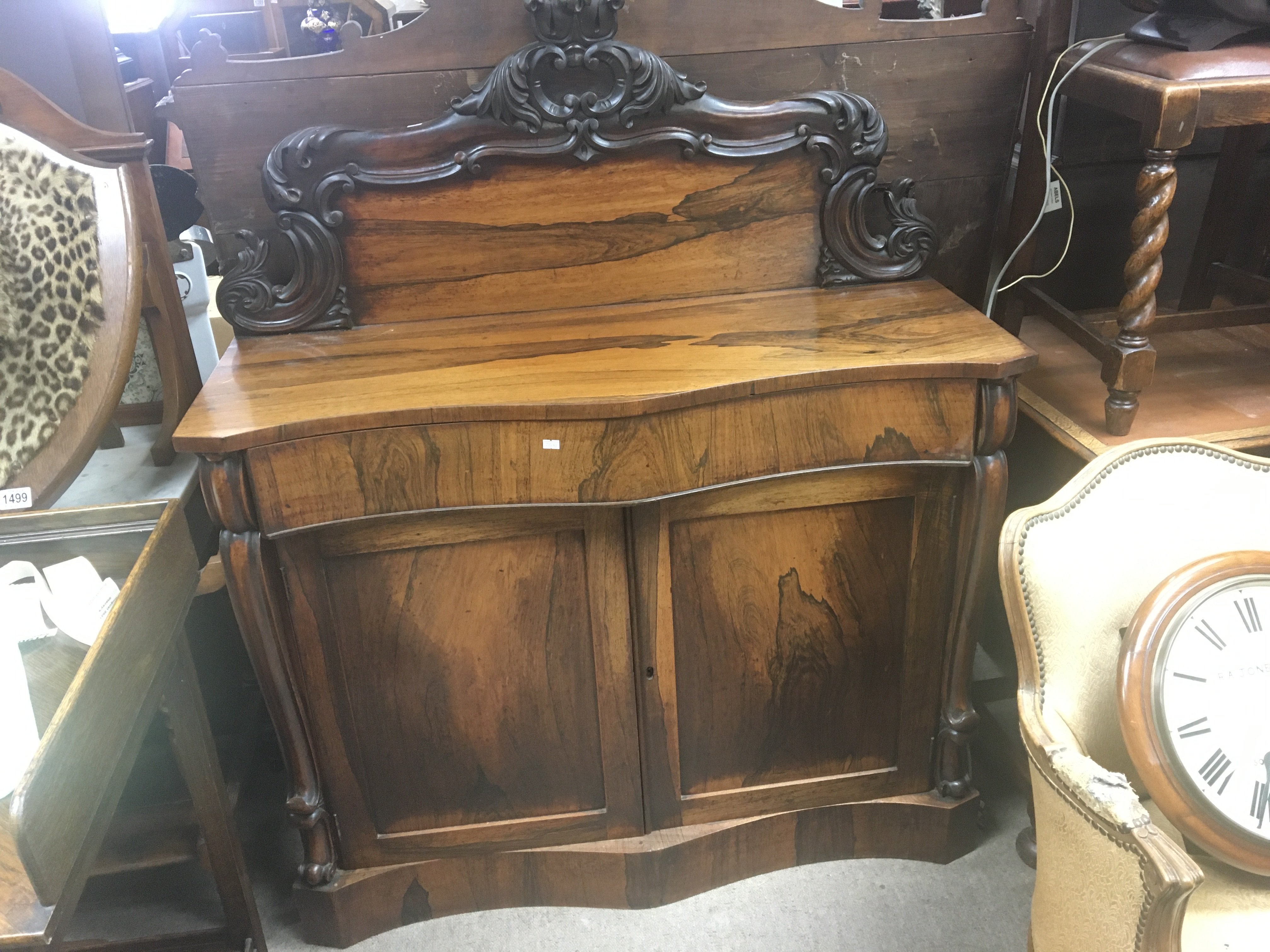 A William IV rosewood chiffonier with a raised back serpentine front above a drawer and cupboards