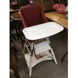 A baby's high chair in red and white.