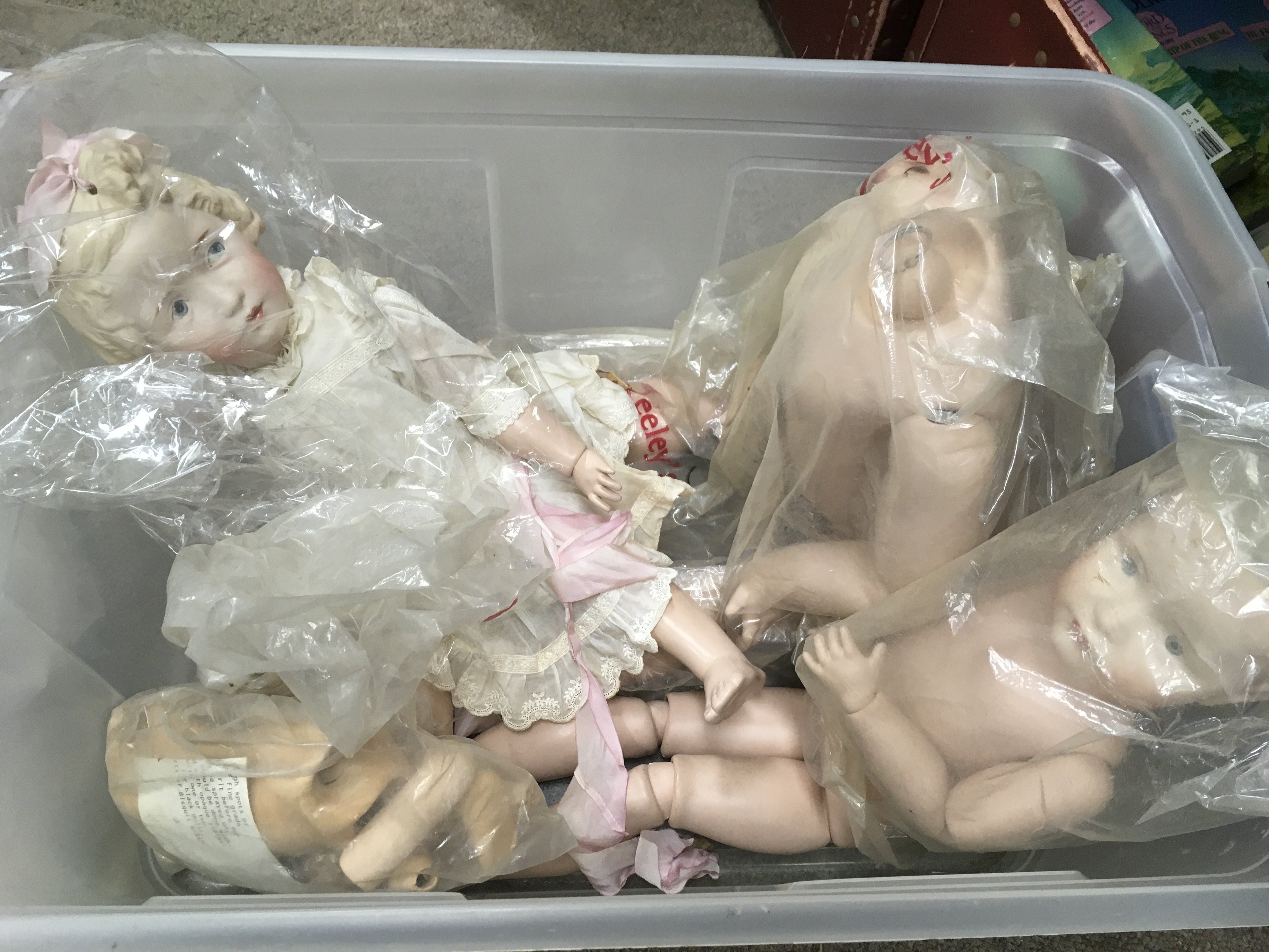 A box of dolls, doll parts, child's Singer sewing machine and related books - NO RESERVE