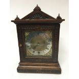 A carved Walnut Edwardian mantel clock with a bras