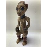A carved and painted west African tribal figure of a seated headhunter. 34cm - NO RESERVE