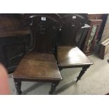 A pair of oak Victorian hall chairs with shaped ba