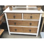 A white painted and oak small chest of drawers fitted with two short and two long drawers.